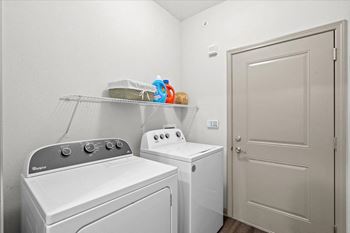 A laundry room with a washer and dryer next to a door